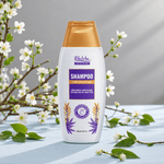 A bottle of blu won Hair shampoo stands on a light blue surface surrounded by white blossoms and green leaves. The bottle is white with a metallic gold cap and a purple and gold label.