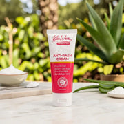 Tube of BluWon Anti-Rash Cream on a wooden surface with plants in the background