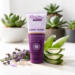 Purple tube of BluWon hand wash with aloe vera slices and lavender on a white surface with plants in the background