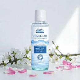 Bottle of Bluwon Micellar Cleansing Water with cherry blossoms and petals on a light background